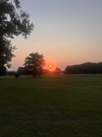 An orange sunset over a wide Alabama field