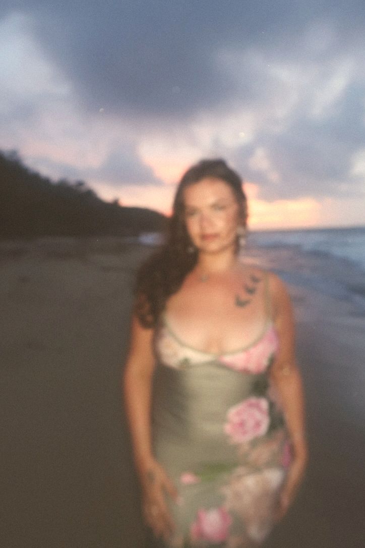 Hannah on a beach at dusk in a floral dress
