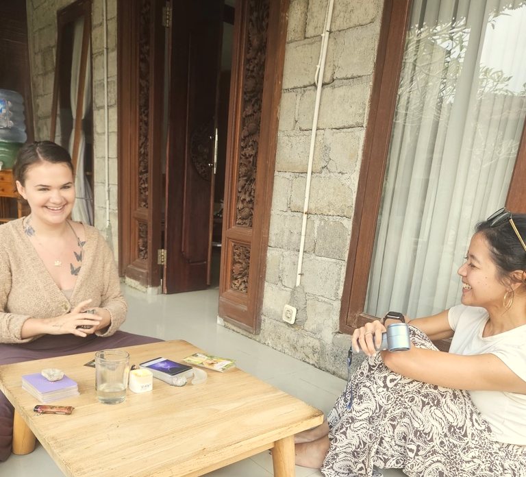 Hannah laughing with a guest during a private tarot reading