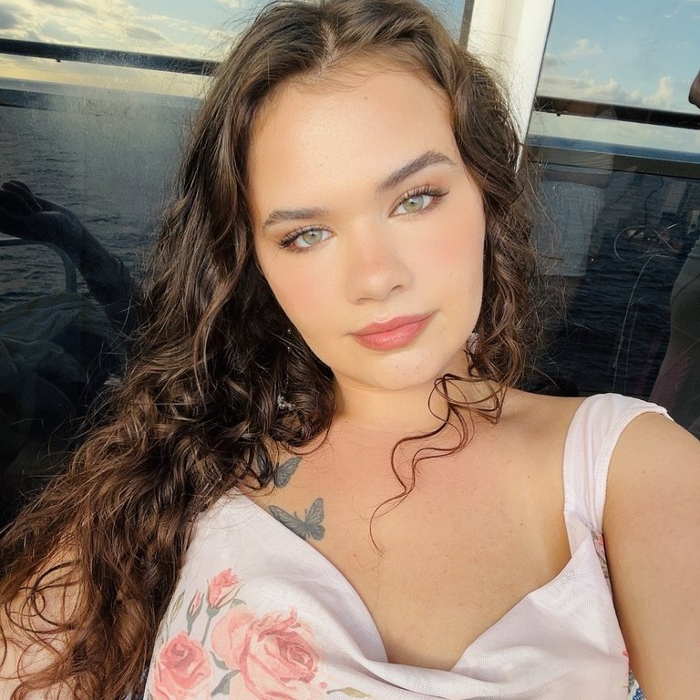 Selfie of Hannah by the ocean in a rose print top