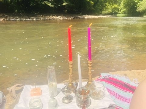 A candle altar set up beside a river